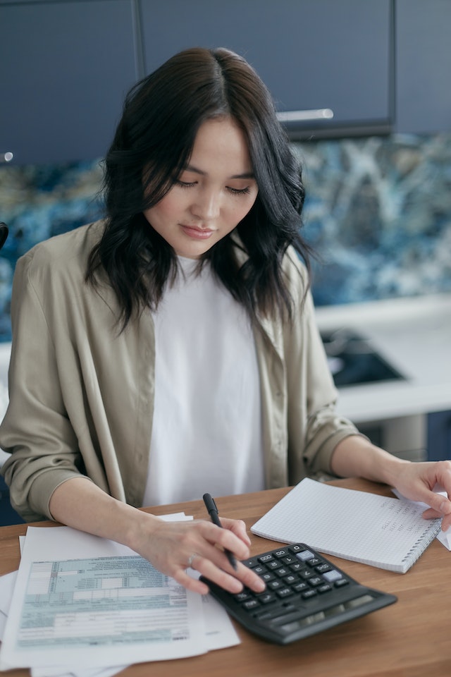 woman calculating her income with calculator 