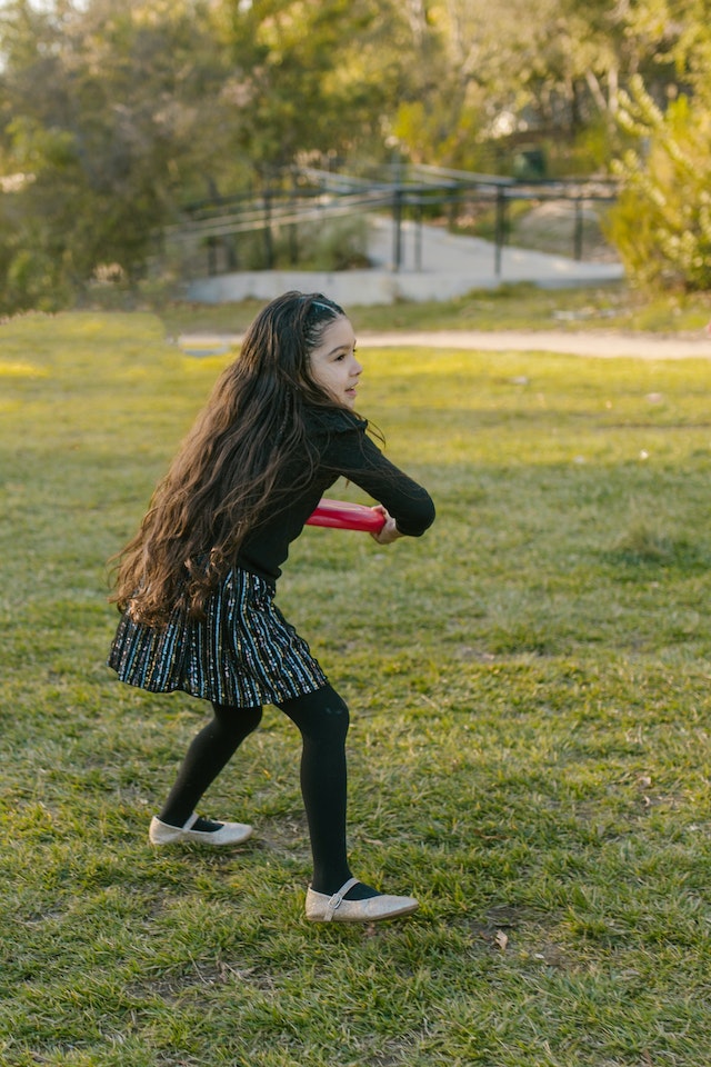 kid throwing frisbee in summer